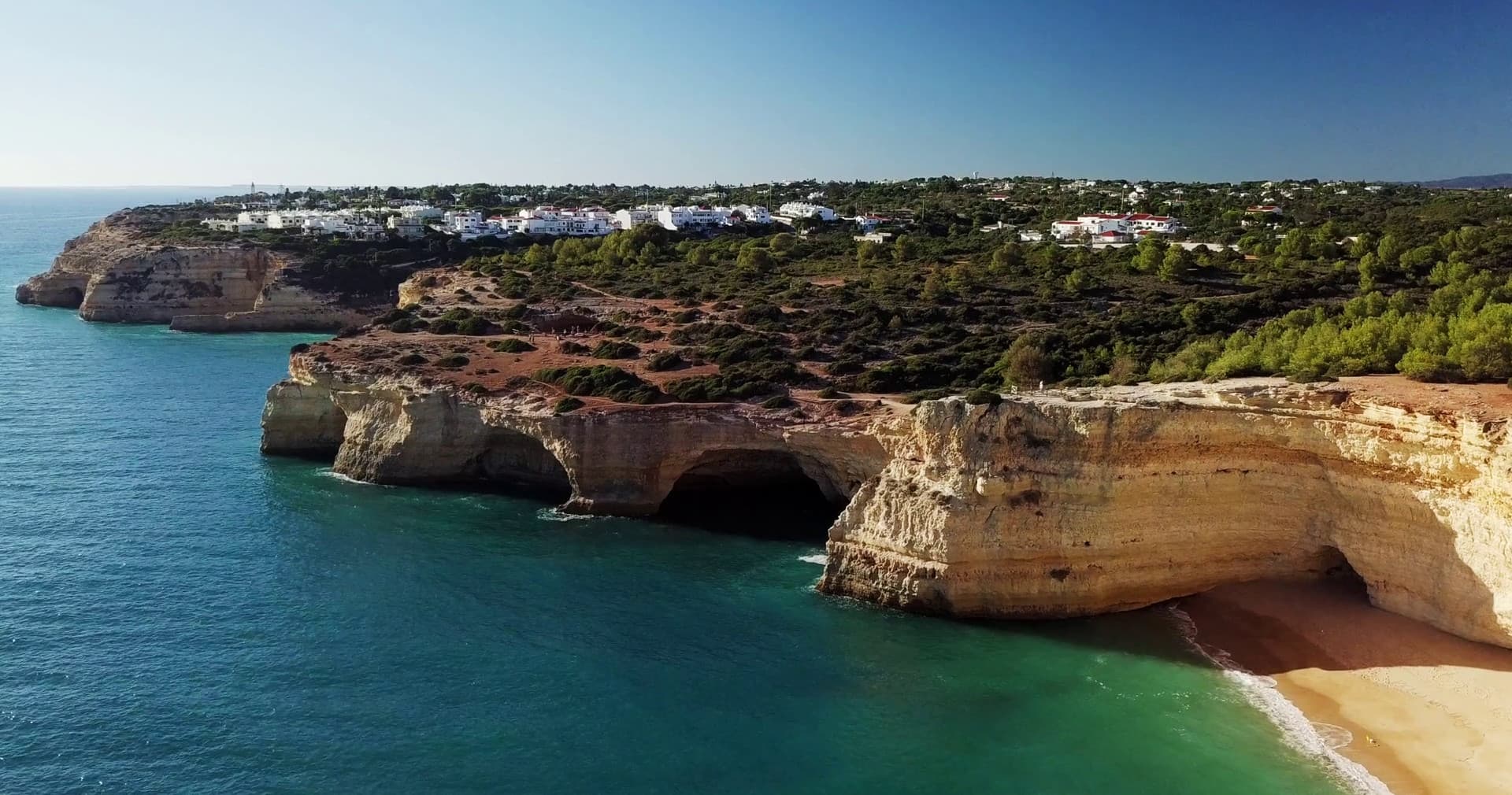 Algarve cliffside sea caves and beach panorama, coastal view