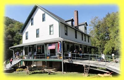 Historic riverside inn with porch for scenic railroad stops