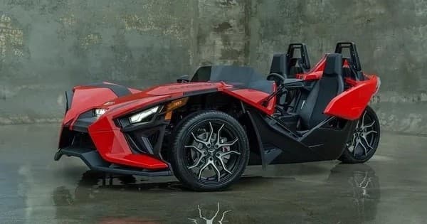 Red Slingshot in industrial garage setting, showroom-style photo