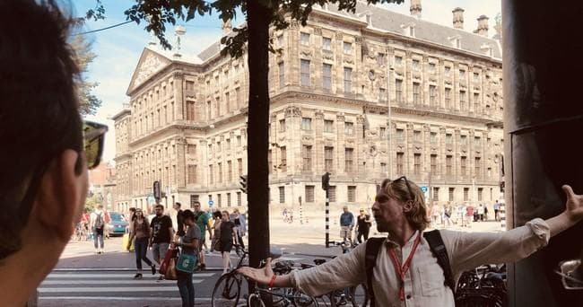 Guide leading outdoor comedy walking tour by historic city square