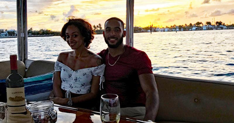 Couple enjoying sunset boat cruise with wine on coastal waters