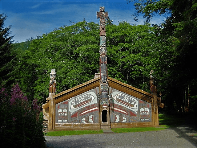 Carved totem longhouse exterior in lush coastal rainforest cultural site
