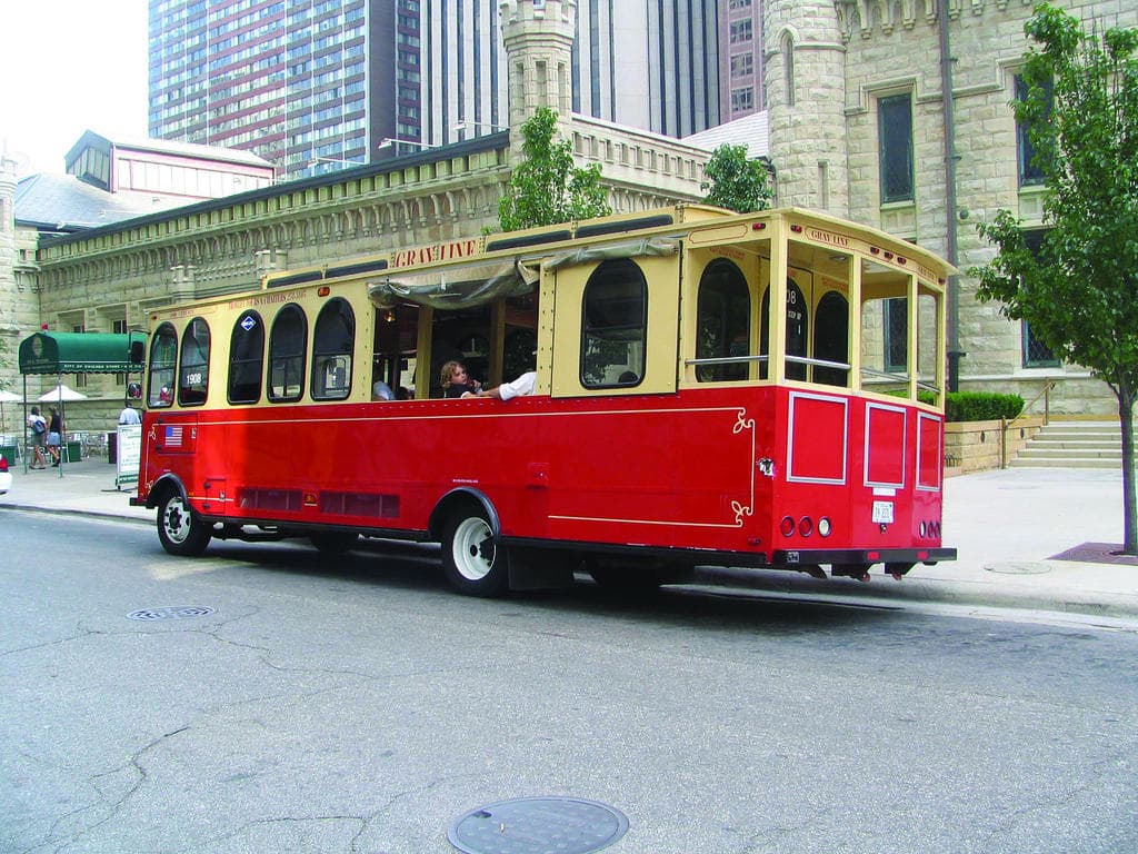 Red vintage trolley cruising downtown Peachtree Street city tour