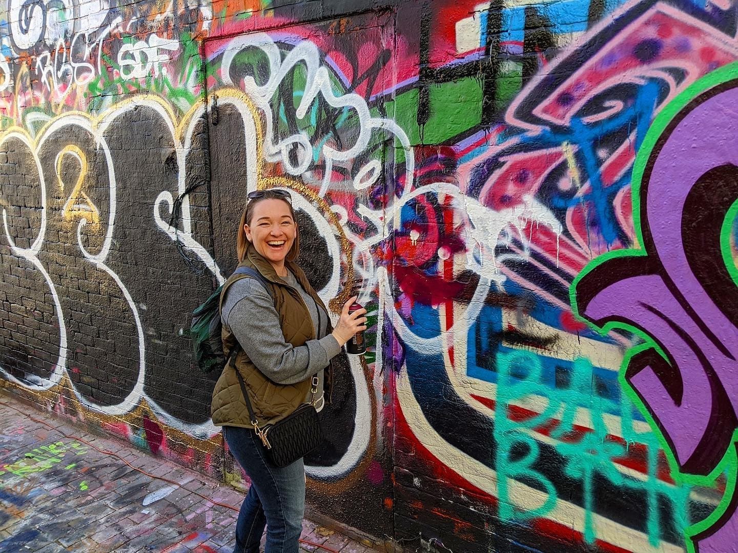 Graffiti alley portrait with visitor posing, urban street art tour