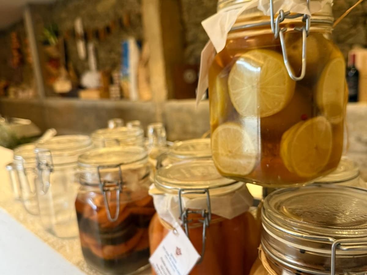 Artisan preserved jars and pickles displayed in rustic pantry