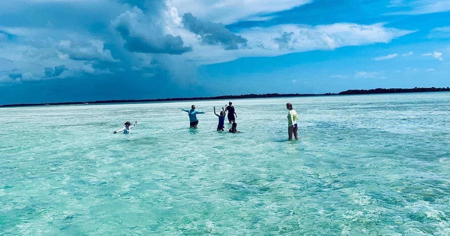 People wading in shallow turquoise flats off Key West, eco tour