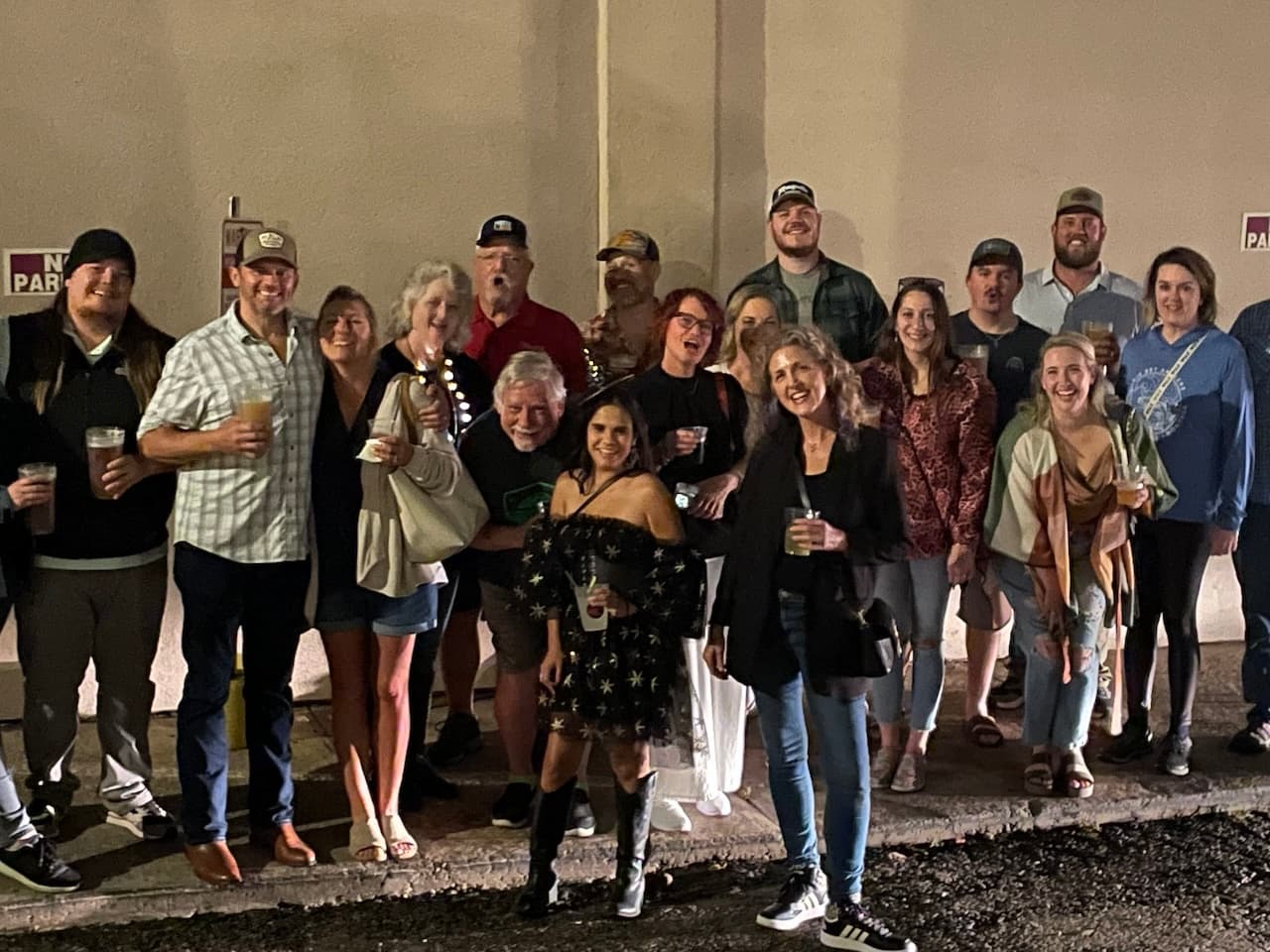 Large group posing on sidewalk during nighttime haunted walking tour