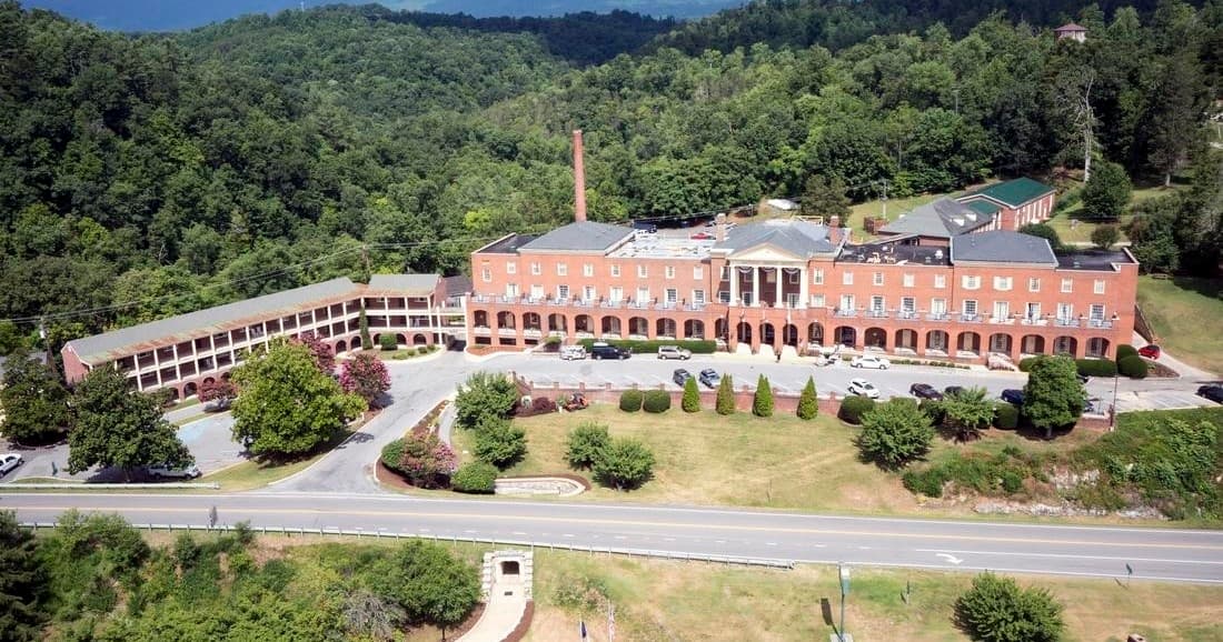 Aerial view of historic mountain hotel resort surrounded by forests in VA