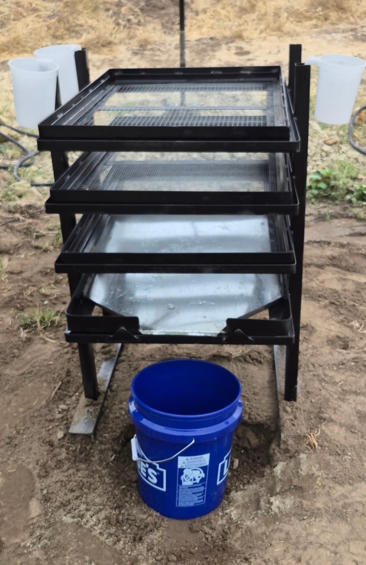 Multi-tier sifting screens and bucket on sandy dig site