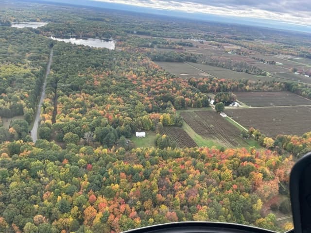Autumn helicopter tour over colorful fall farmland and forests