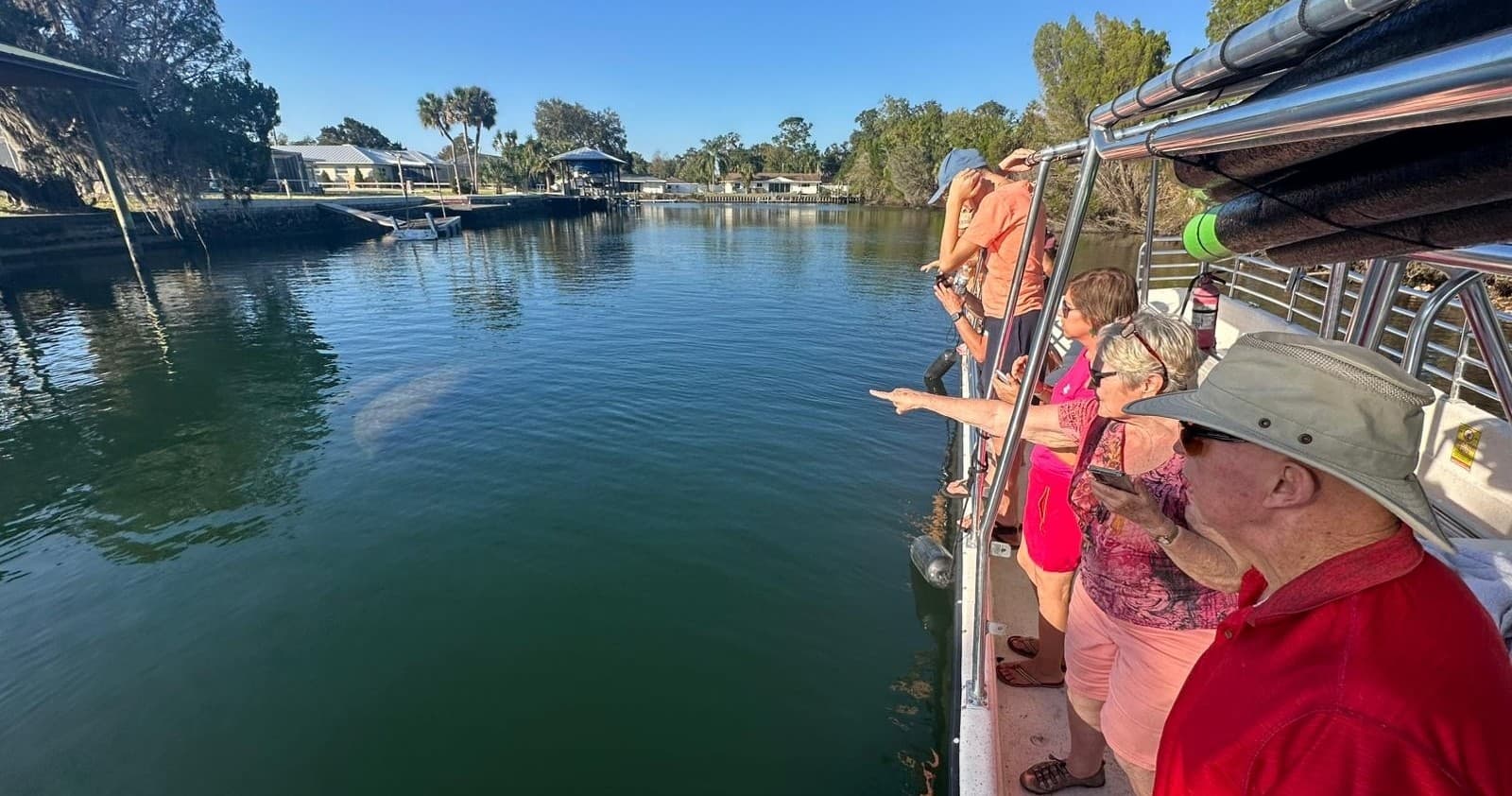 Passengers on tour boat enjoying calm river scenery and wildlife