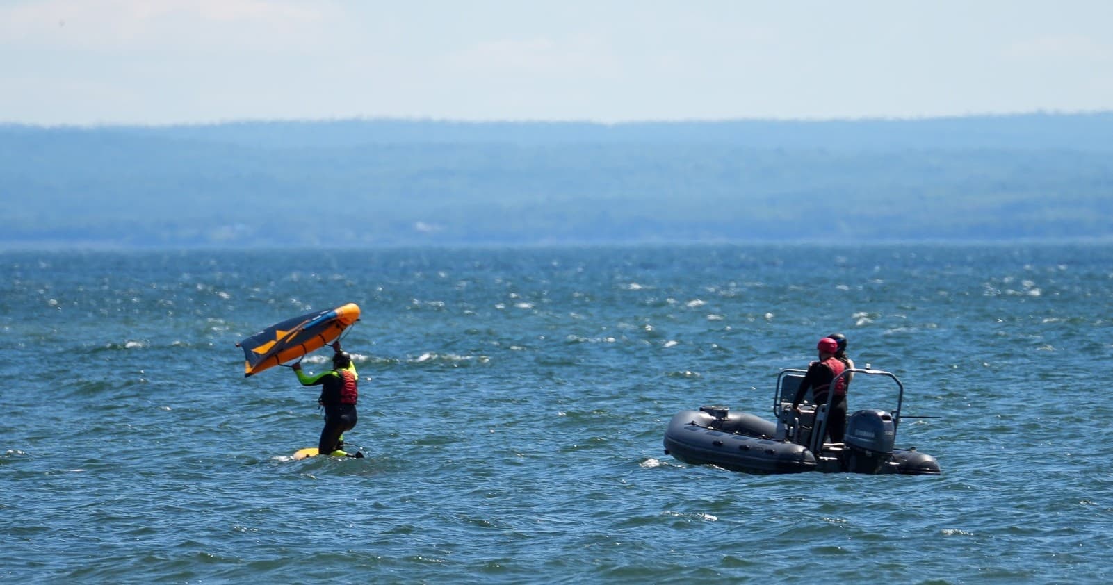 Kiteboarder on open water assisted by RIB during training