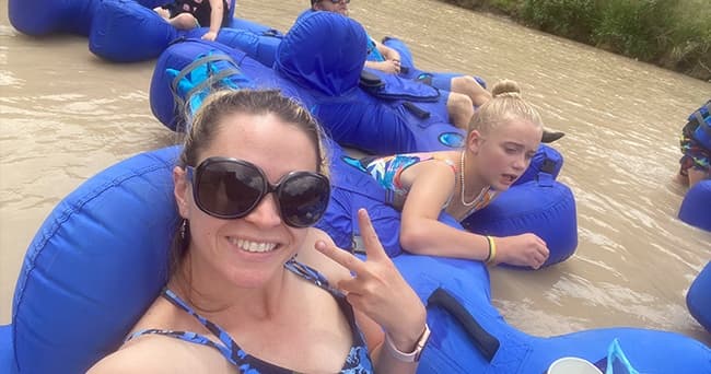 Friends tubing on muddy river in inflatable tubes, summer fun