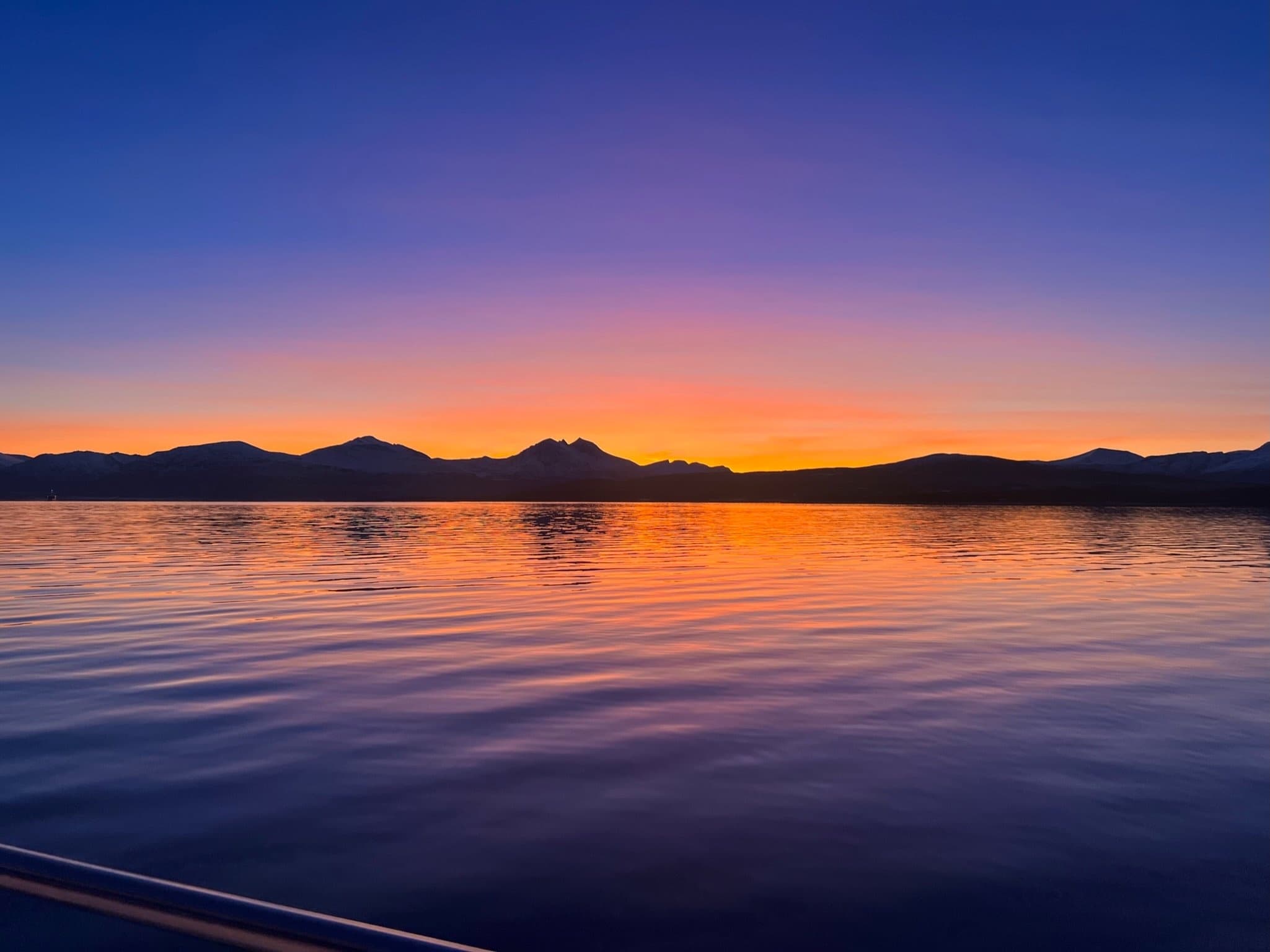 Sunset over serene sea with distant islands and calm waters