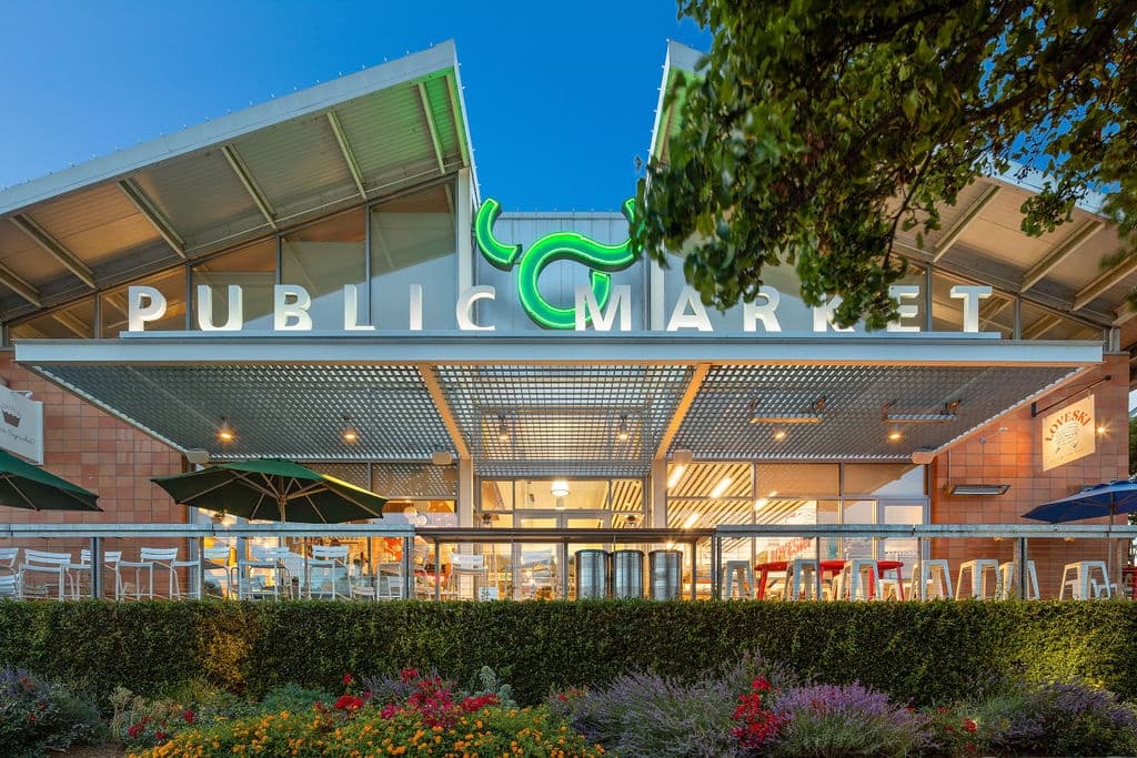 Public market entrance with outdoor seating and awnings
