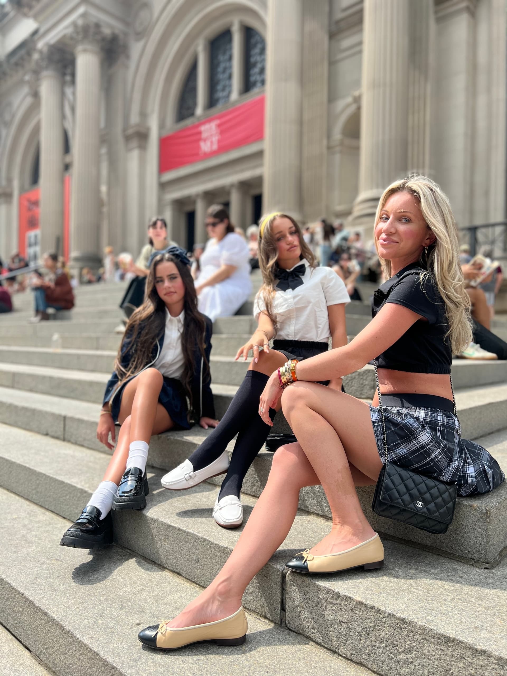 Friends sitting on steps at The Met Museum enjoying city tour