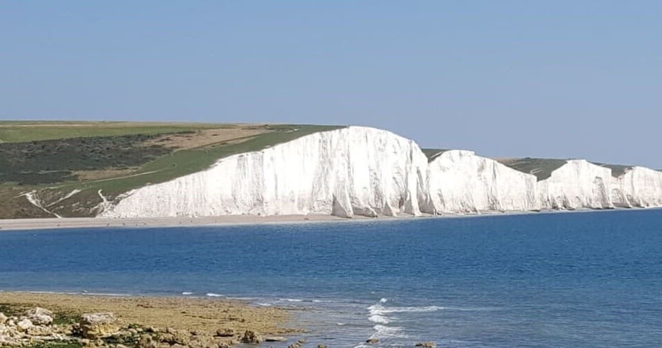 Seaside view of white chalk cliffs and calm English Channel coast
