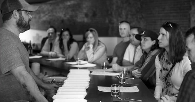 Guests attending guided tasting and culinary talk in a tasting room