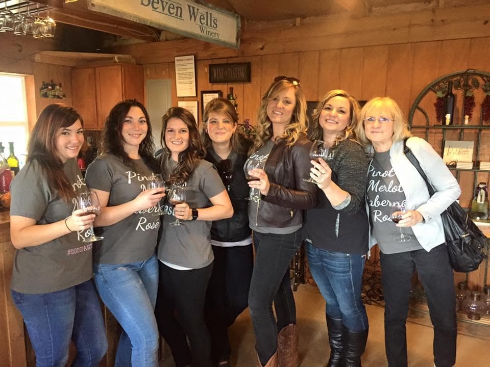 Group wine tasting inside rustic winery tasting room