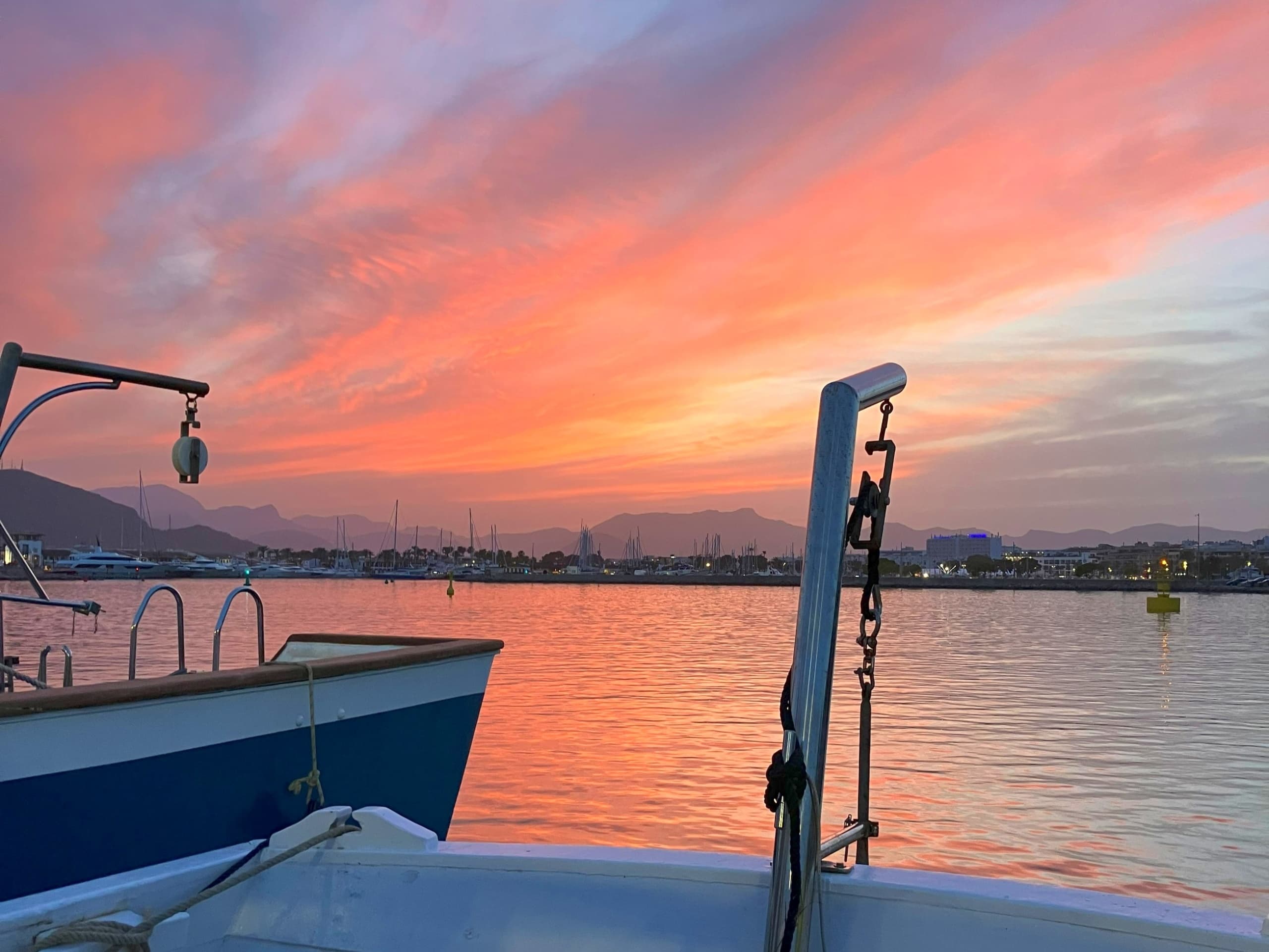 Sunset harbor view from deck with moored boats in Mallorca