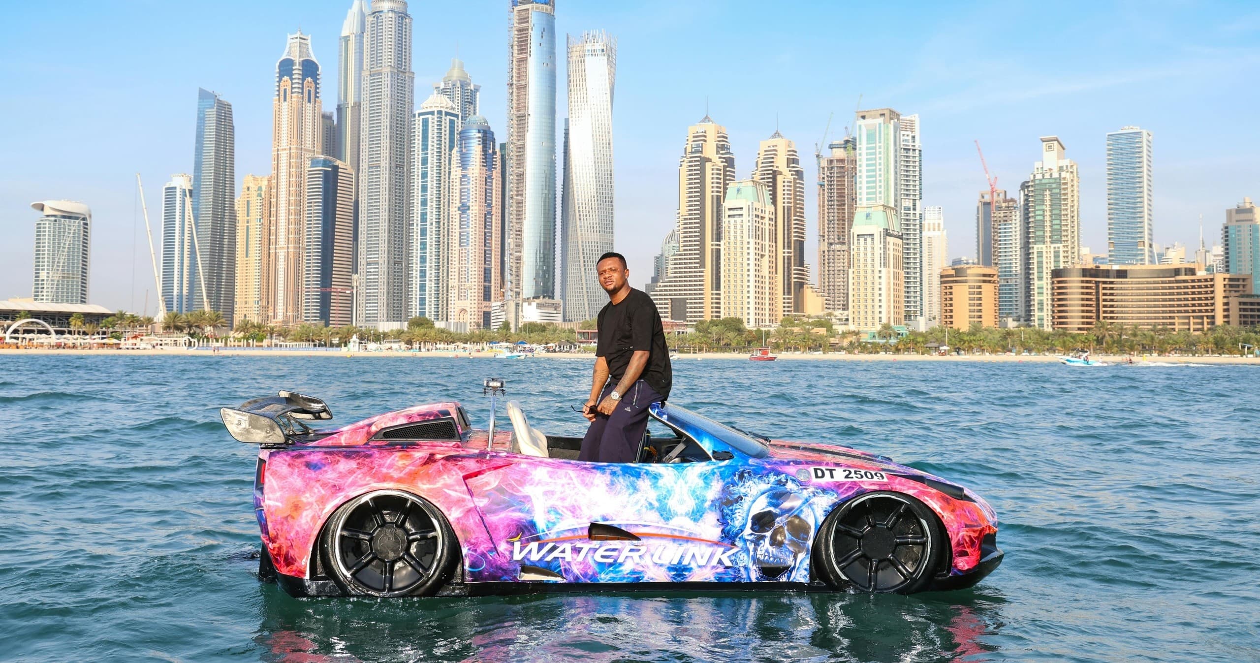 Amphibious sports car cruising Dubai Marina waters with driver