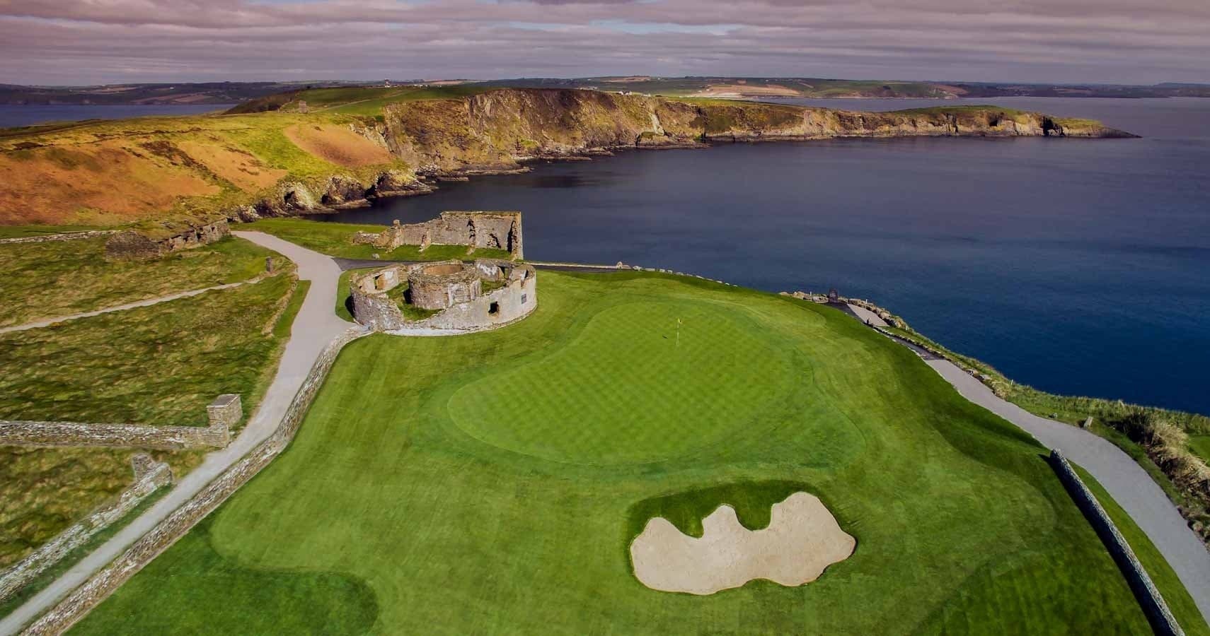 Panoramic seaside golf course and coastal fortress on rugged shore