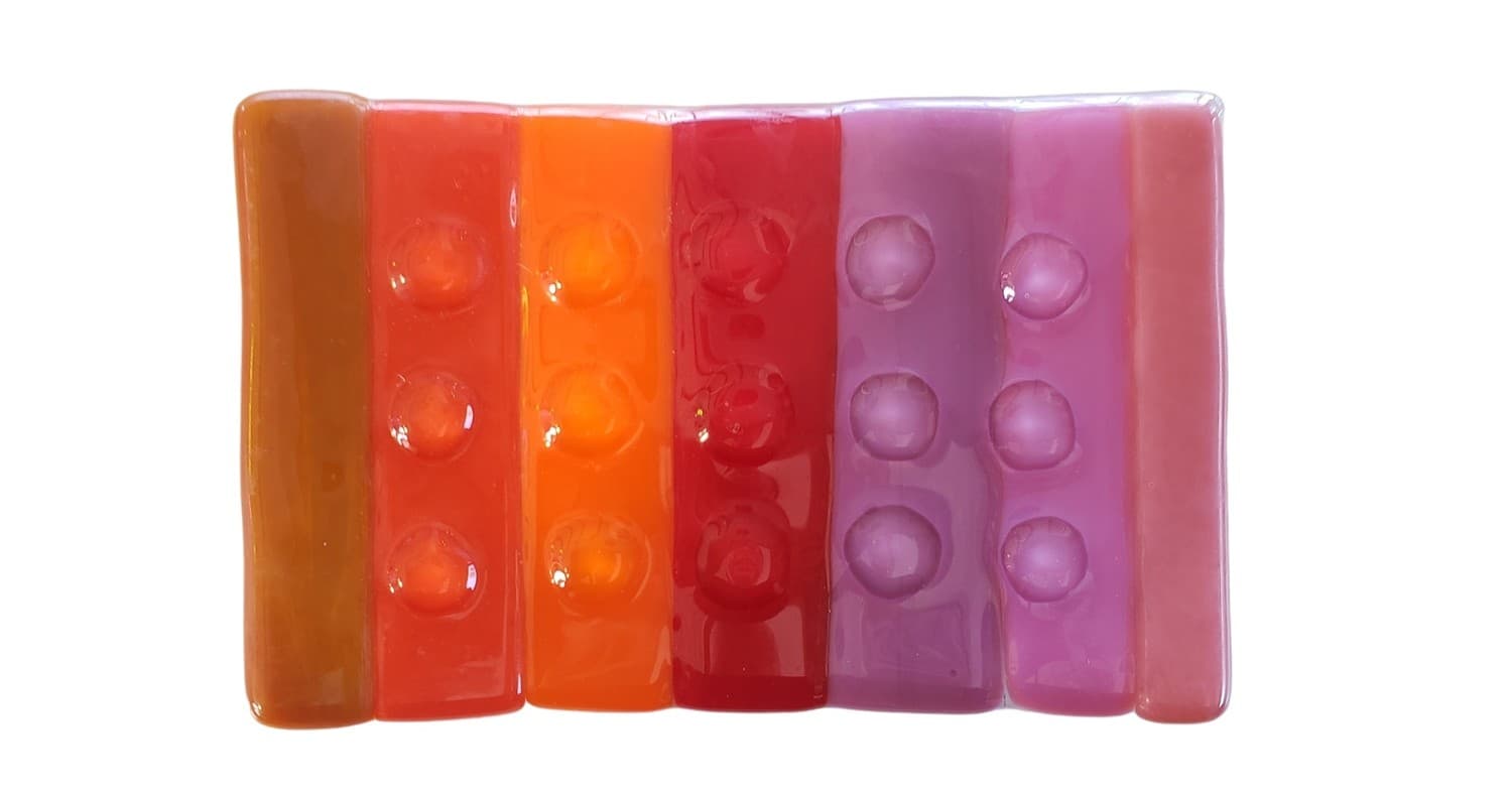 Colorful fused glass bars art pieces photographed on white