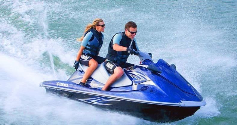 Two riders jet skiing on ocean waves off Fort Lauderdale coast