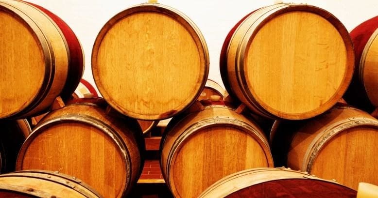 Stacked oak wine barrels in winery cellar showcasing aging process
