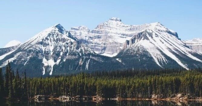Snow-capped mountains reflected in alpine lake, scenic Rockies