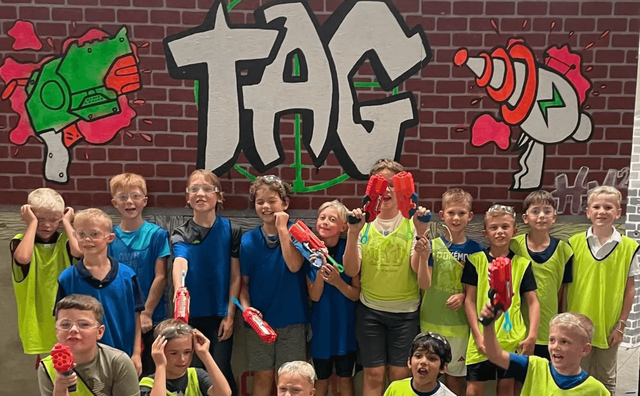 Youth team holding foam blasters in indoor tag arena