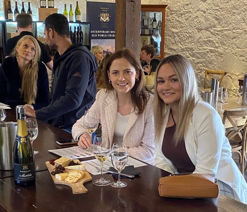 Friends enjoying wine tasting and cheese board at bar counter