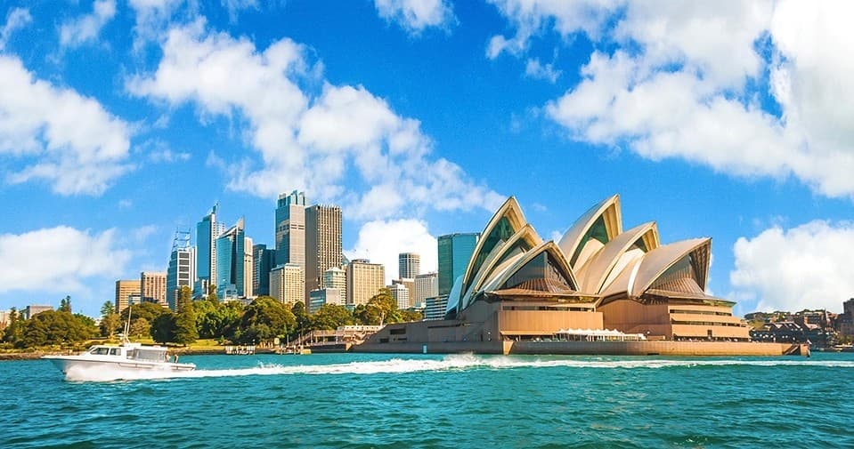 Sydney Opera House and harbor skyline under clear blue sky