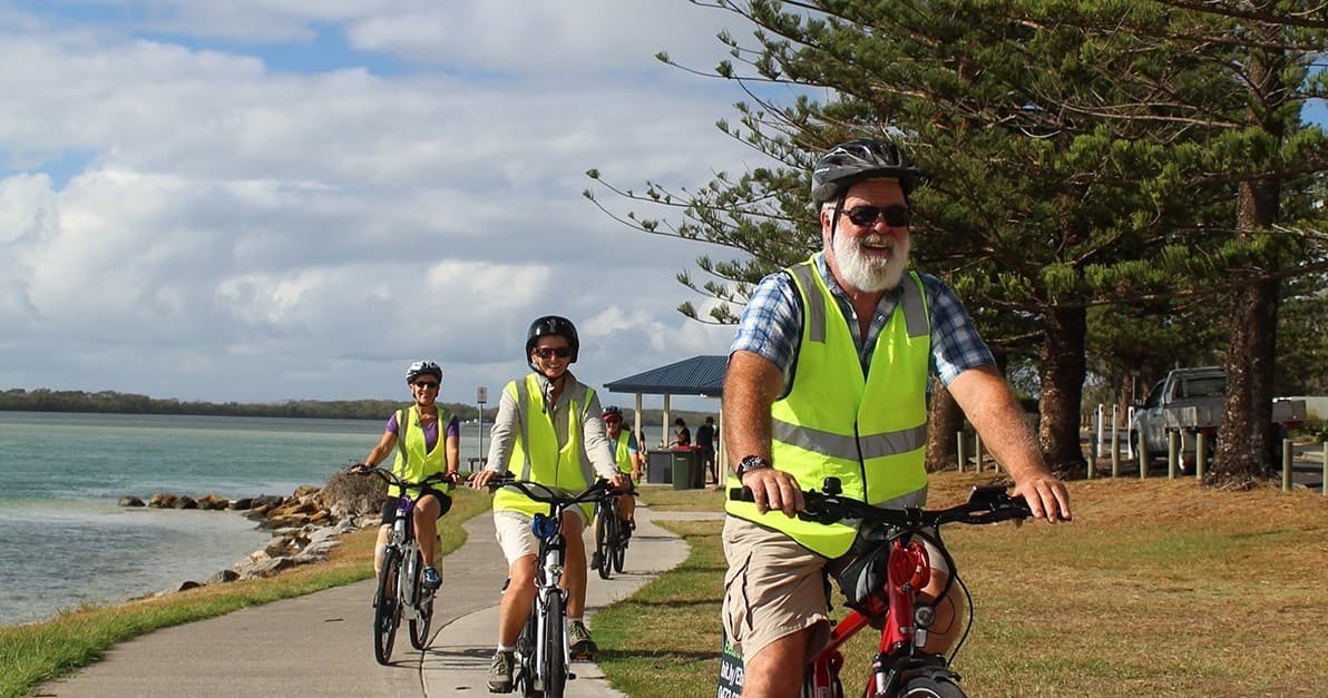 Couple enjoying coastal lookout while resting with bikes