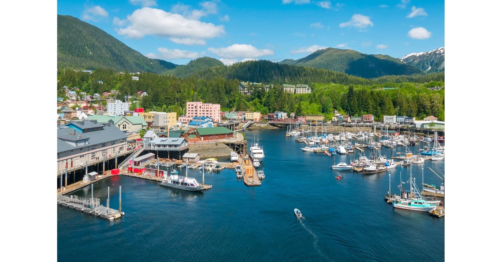 Aerial view of Alaskan fishing harbor and coastal mountains scenery