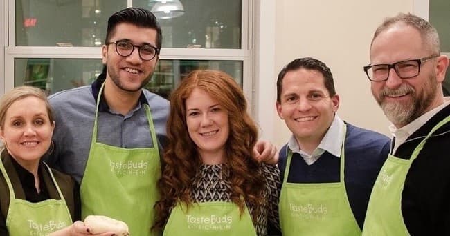 Team of chefs and students posing in NYC culinary workshop studio