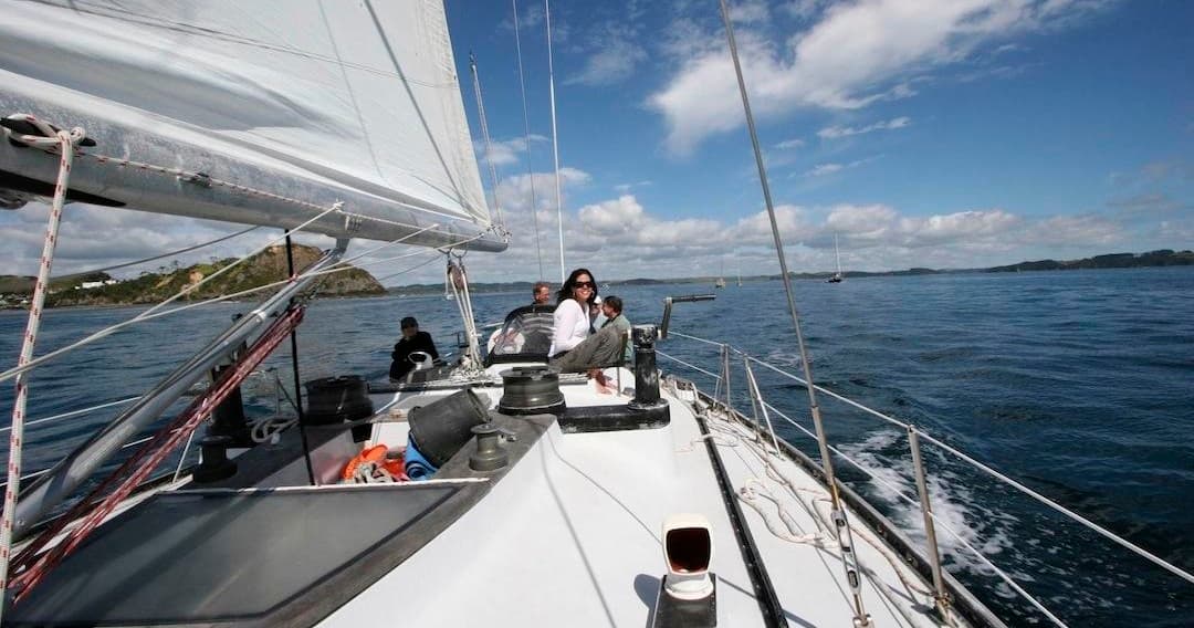 Sailboat deck underway with crew navigating near Bay of Islands