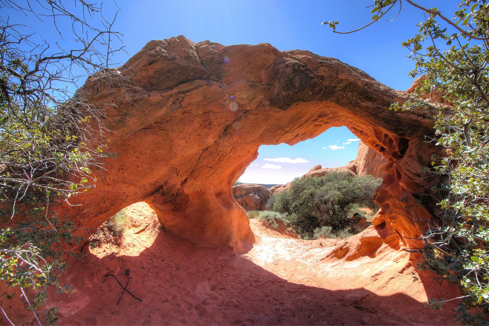 Natural red rock arch framing desert landscape near Zion