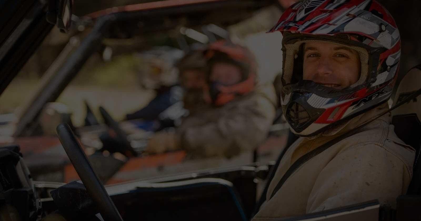 Smiling UTV driver and passenger in off-road vehicle, trail ride