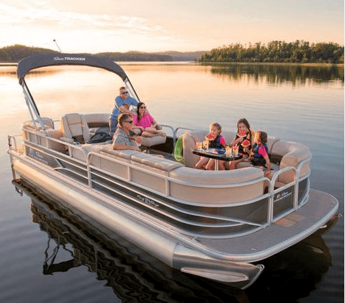 Family enjoying pontoon boat cruise on calm sunset lake