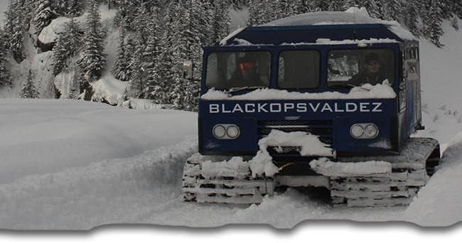 Snowcat tracked vehicle traversing deep snow for glacier access