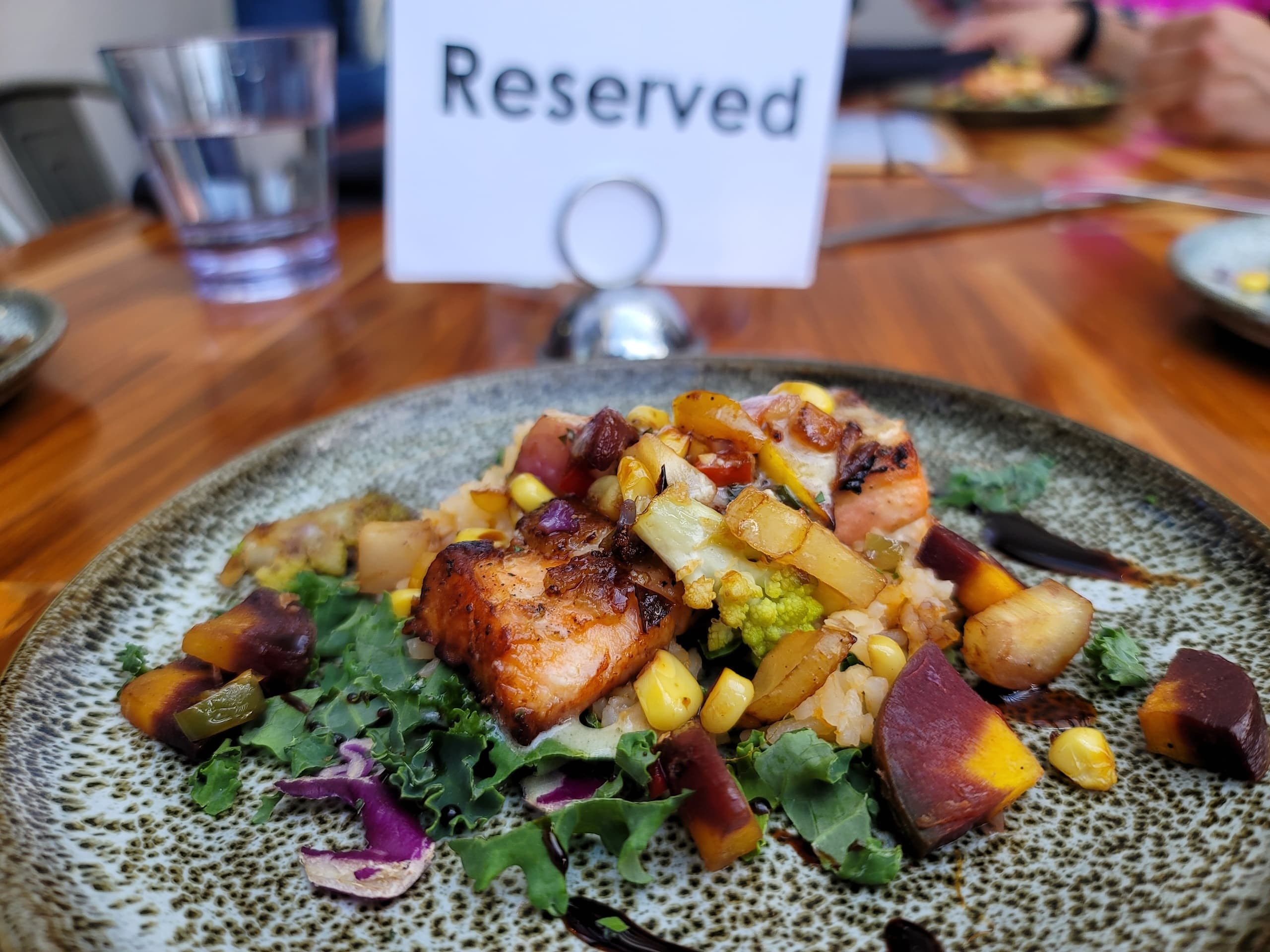 Pan-seared salmon salad served at reserved table setting