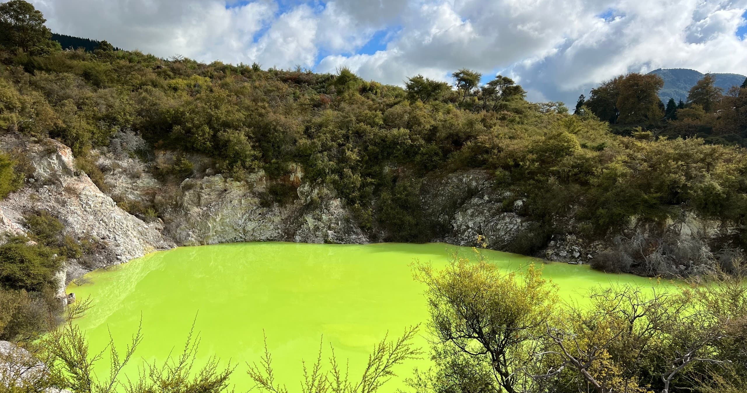 Vibrant geothermal green lake in volcanic basin, scenic view