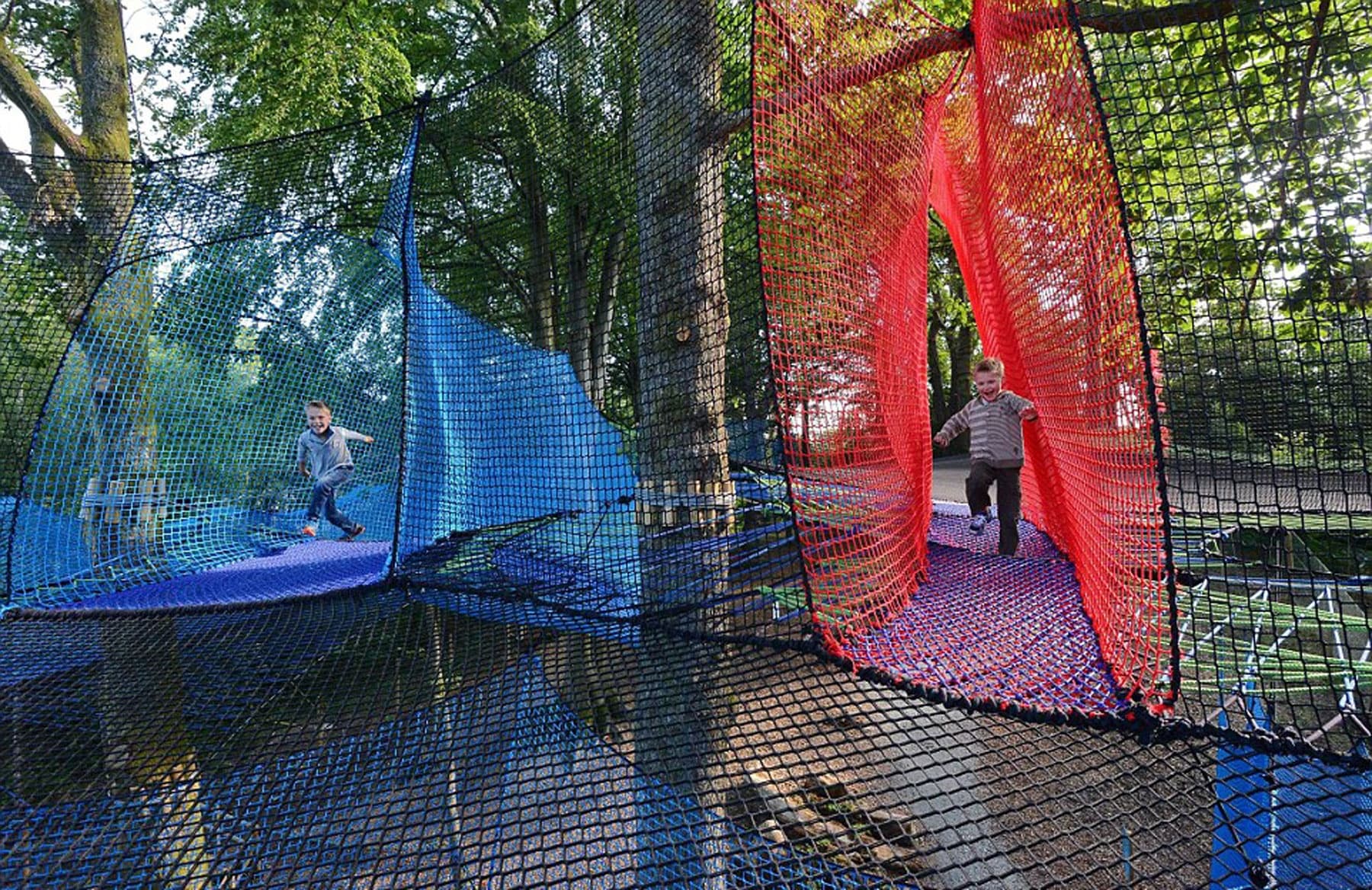 Colorful netted aerial playground among trees at park