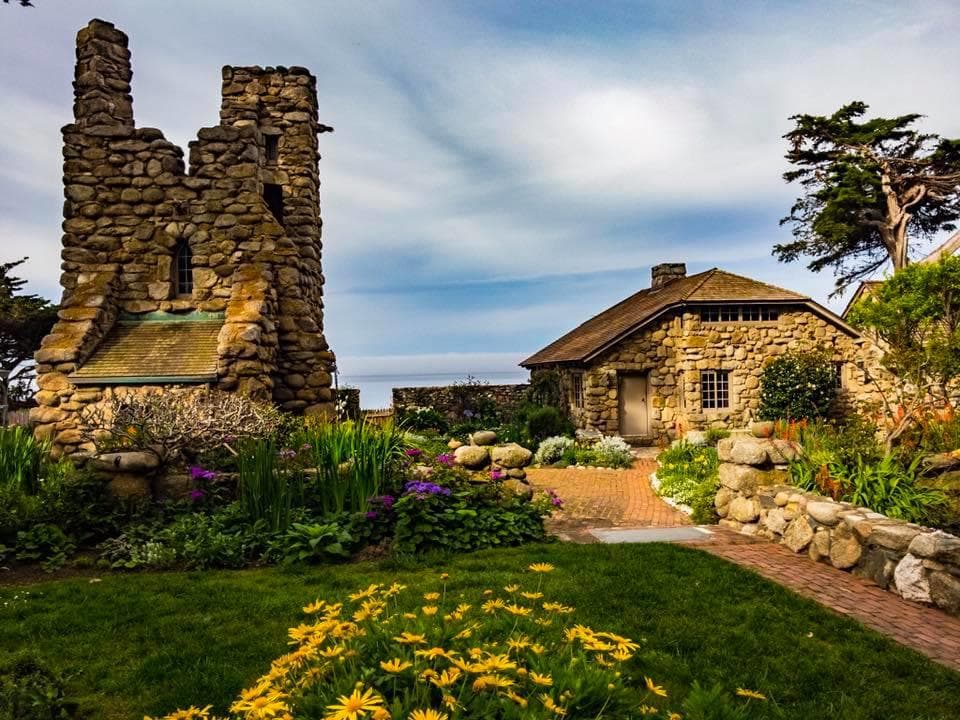 Garden and stone cottage beside dramatic coastal bluff