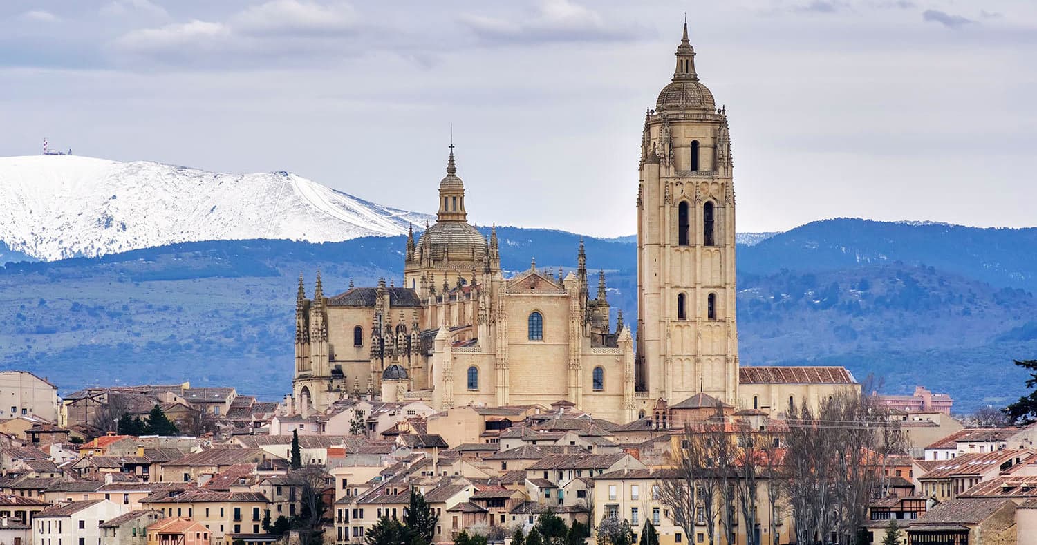 Segovia cathedral skyline with snow-capped mountains in background
