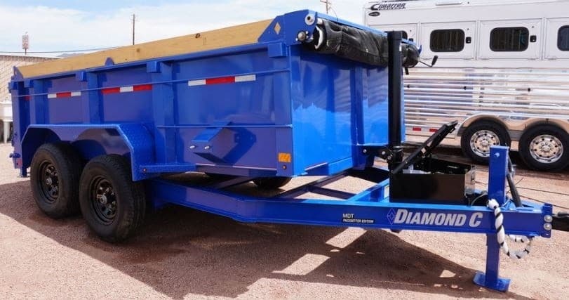 Blue dump trailer at outdoor rental lot for hauling equipment