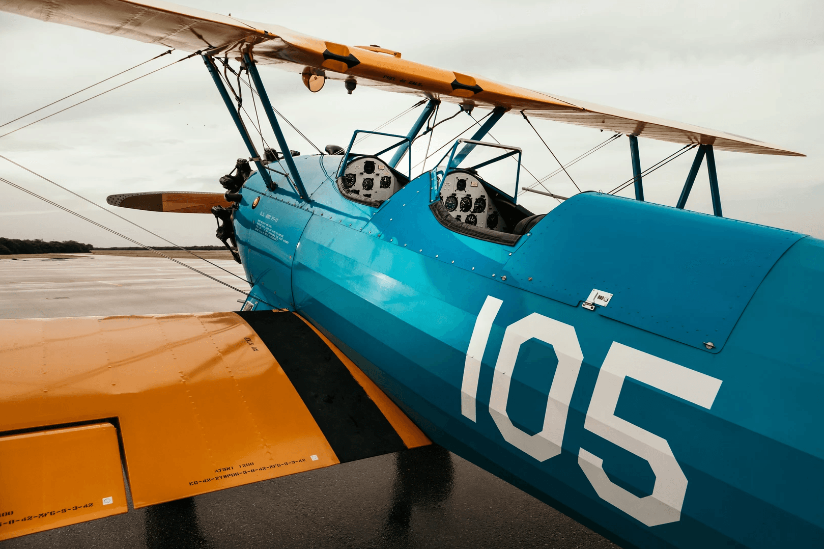 Close-up of vintage blue biplane cockpit and fuselage on tarmac