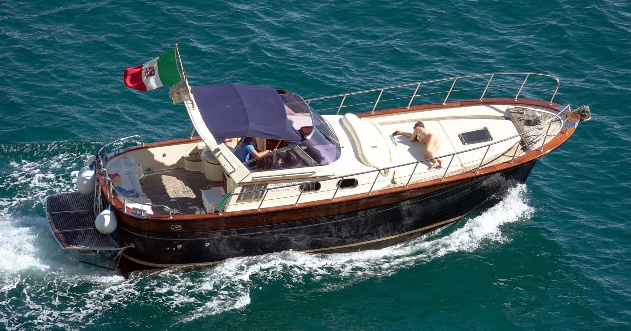 Classic wooden boat cruising blue Mediterranean waters near Capri