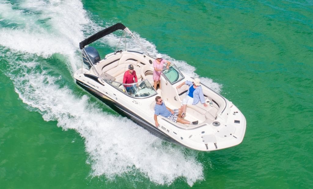 Speedboat cutting through emerald lake water, passengers enjoying ride